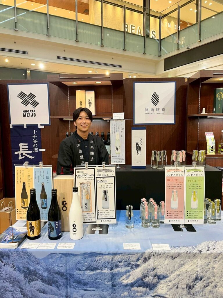 Visitors enjoying sake from Tsunan Town at the festival